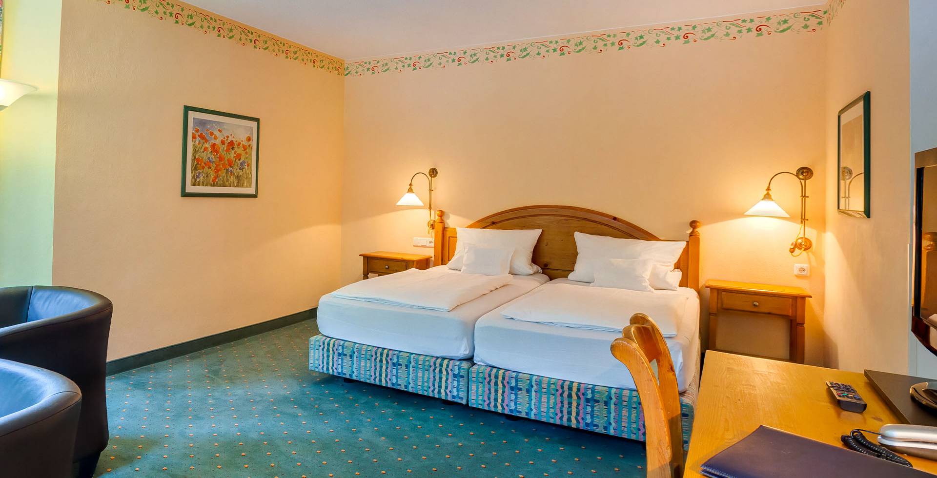 Einladendes Doppelbett im Hotelzimmer mit Holzmöbeln im bayrischen Design.