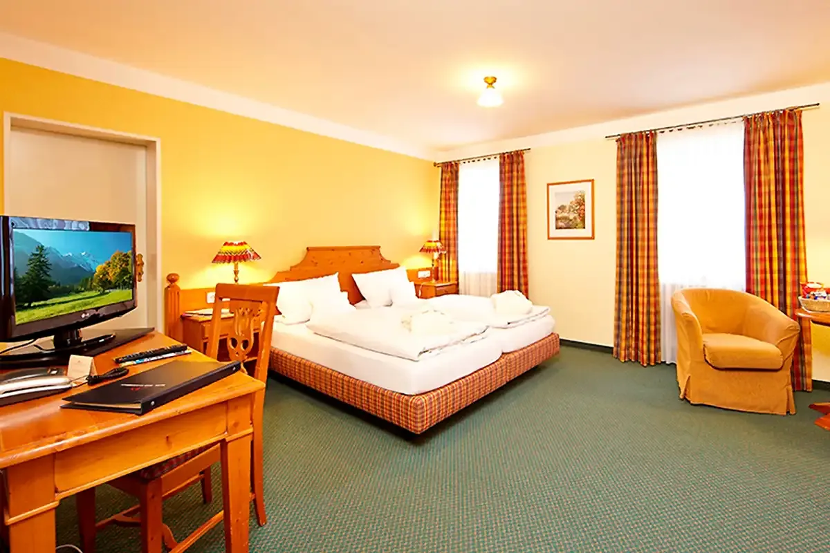 ChatGPT: Doppelzimmer mit viel Platz zum Erholen, gemütlichem Doppelbett, TV und Sitzecke zum Verweilen.